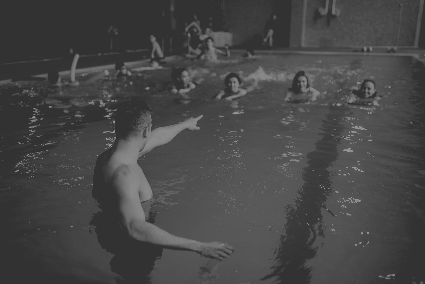 Instructor Works with Class in Swimming Pool